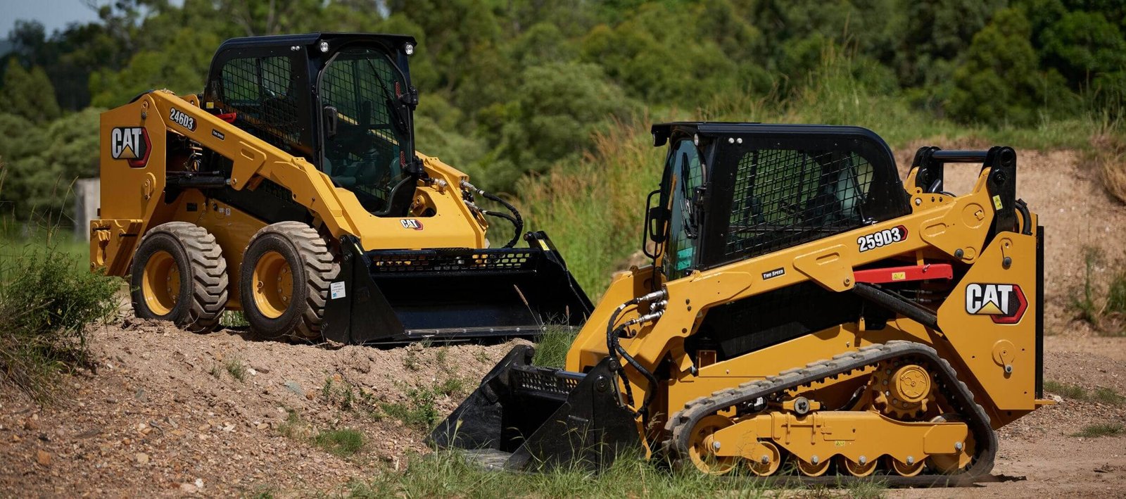 two skid steers working in the field